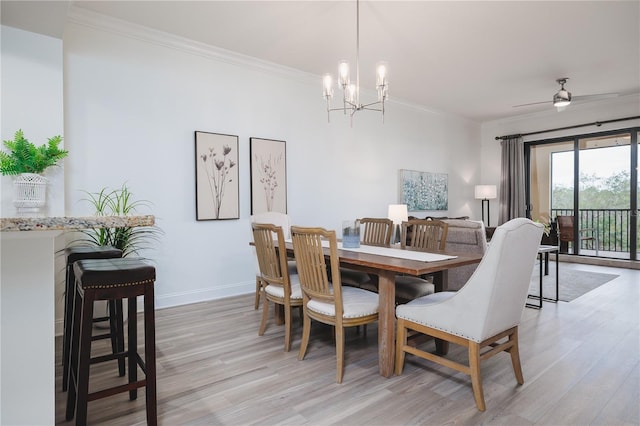 dining space featuring ceiling fan with notable chandelier, light hardwood / wood-style flooring, and crown molding