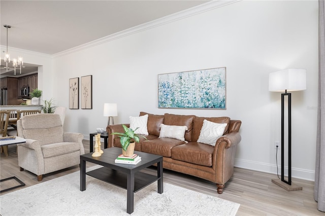 living room featuring light hardwood / wood-style floors, ornamental molding, and an inviting chandelier