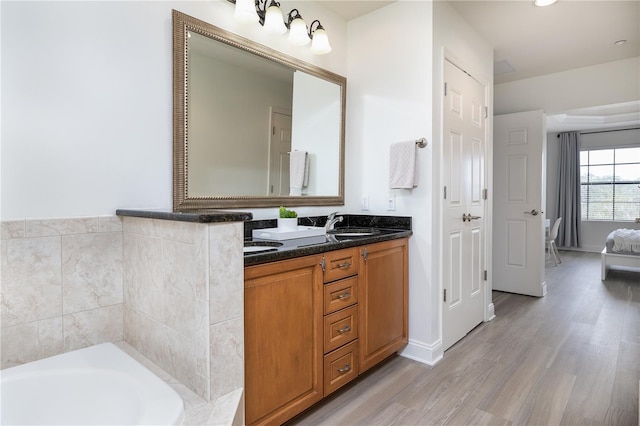 bathroom with hardwood / wood-style floors, vanity, and a bathing tub