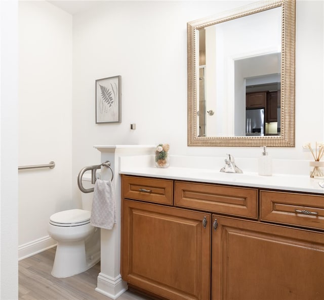 bathroom featuring hardwood / wood-style flooring, vanity, and toilet