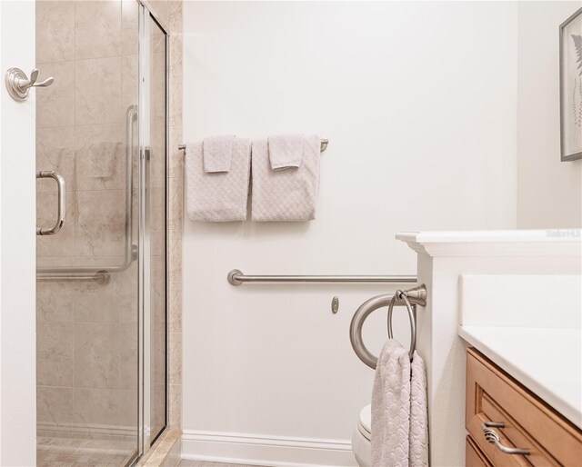 bathroom featuring vanity, toilet, and a shower with shower door