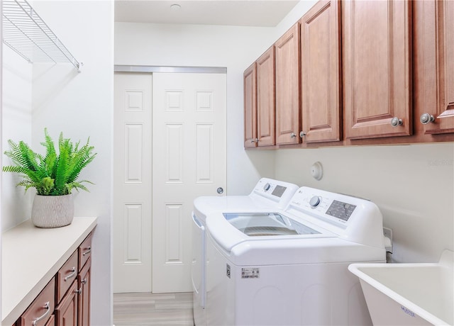 laundry room with cabinets, washer and clothes dryer, and sink