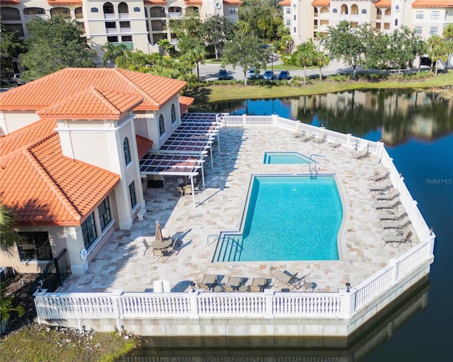 view of pool with a water view and a patio