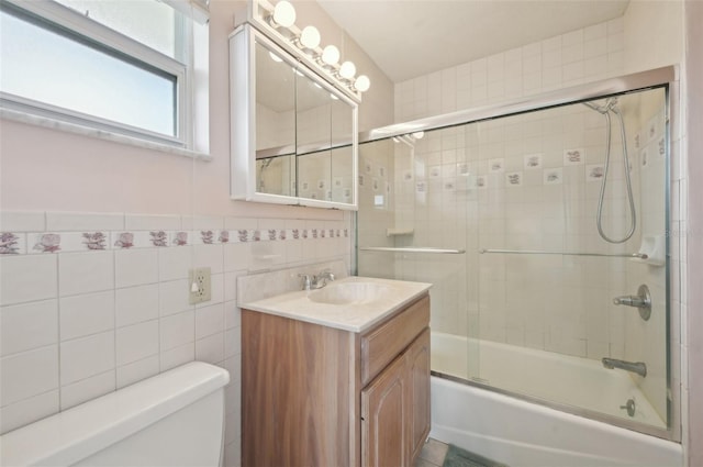 full bathroom featuring vanity, toilet, enclosed tub / shower combo, and tile walls