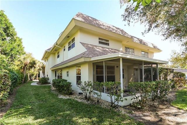 back of house featuring a yard and a sunroom