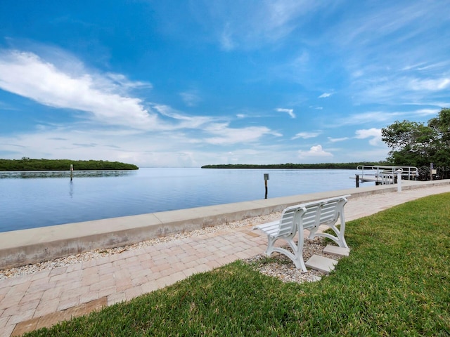 view of dock with a water view and a yard