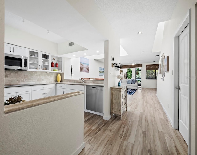 kitchen with white cabinetry, appliances with stainless steel finishes, tasteful backsplash, light hardwood / wood-style flooring, and sink