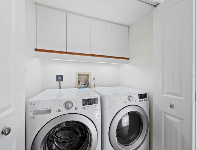 laundry area featuring cabinets and washing machine and dryer