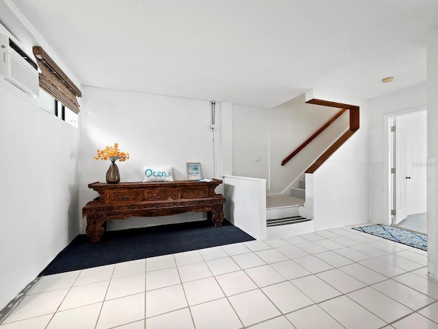 interior space with a wall unit AC and light tile patterned flooring