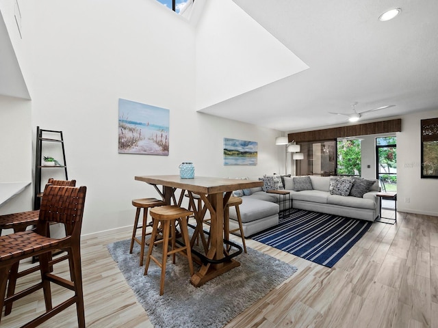 dining space with ceiling fan and light hardwood / wood-style flooring