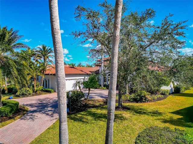 mediterranean / spanish-style house with a front yard and a garage