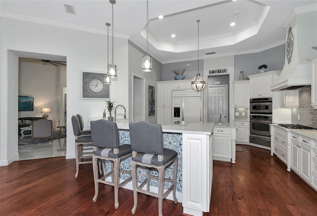 kitchen featuring white cabinets, dark hardwood / wood-style flooring, stainless steel appliances, and hanging light fixtures