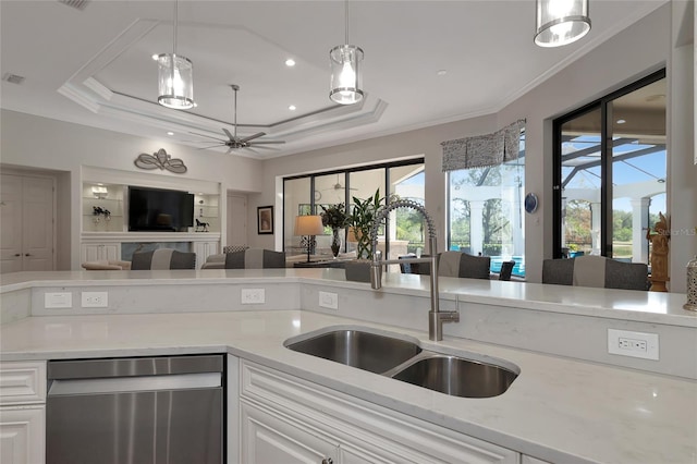 kitchen with a raised ceiling, dishwasher, and decorative light fixtures