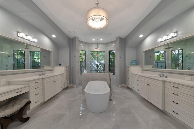 bathroom featuring plus walk in shower, vanity, and a wealth of natural light