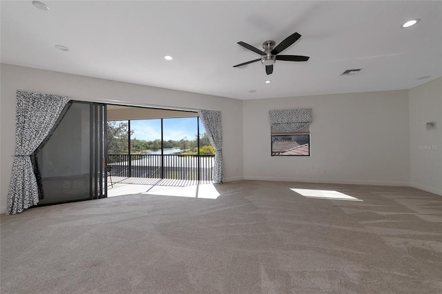 carpeted spare room with ceiling fan