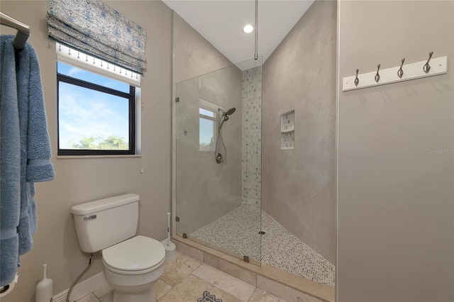 bathroom featuring a tile shower and toilet