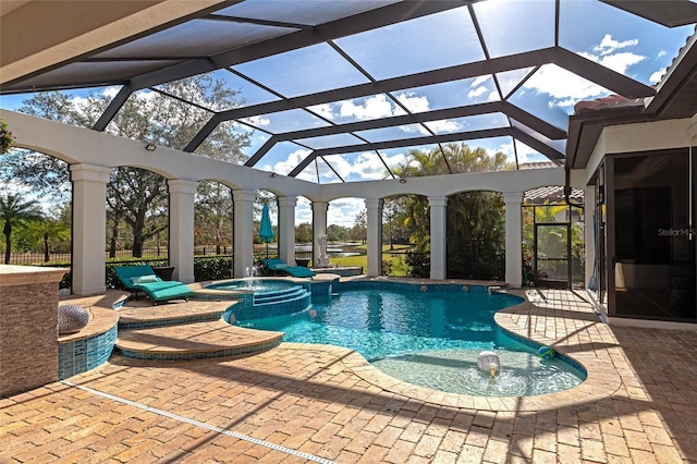 view of swimming pool featuring a lanai, an in ground hot tub, pool water feature, and a patio