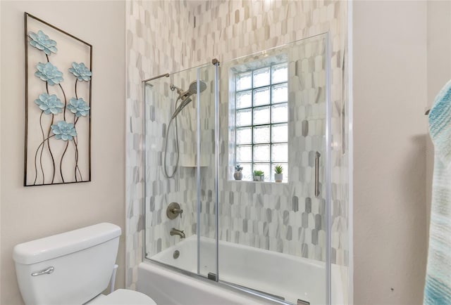 bathroom with shower / bath combination with glass door and toilet