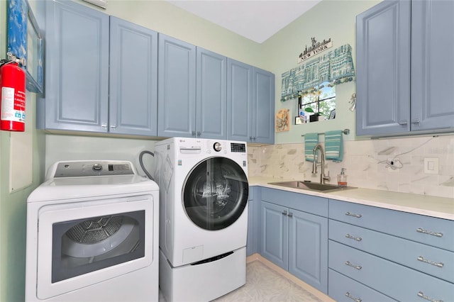 laundry room with cabinets, washing machine and dryer, and sink