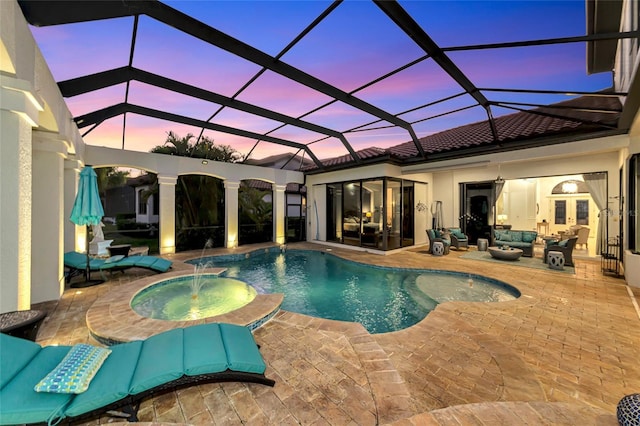 pool at dusk with outdoor lounge area, a lanai, pool water feature, an in ground hot tub, and a patio