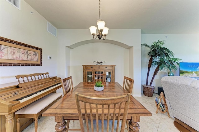 tiled dining area featuring a chandelier