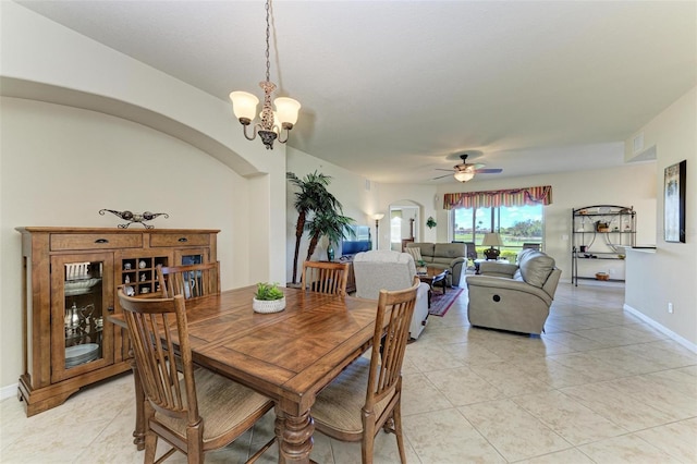 tiled dining area with ceiling fan with notable chandelier