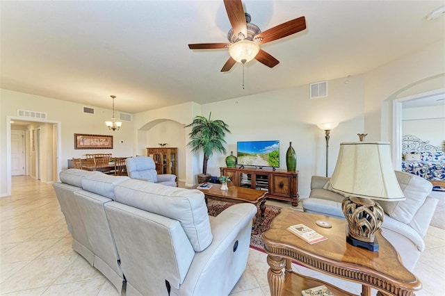 living room with light tile patterned floors and ceiling fan with notable chandelier