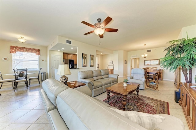 tiled living room featuring ceiling fan with notable chandelier