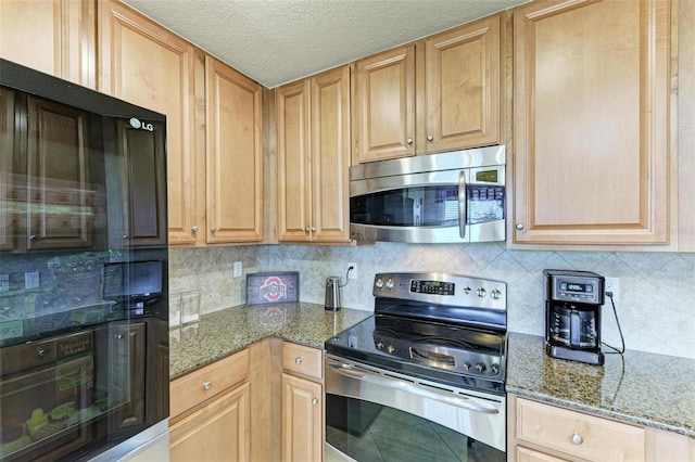 kitchen featuring a textured ceiling, decorative backsplash, stainless steel appliances, and stone counters