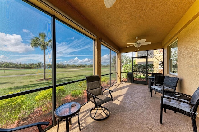 sunroom / solarium featuring ceiling fan