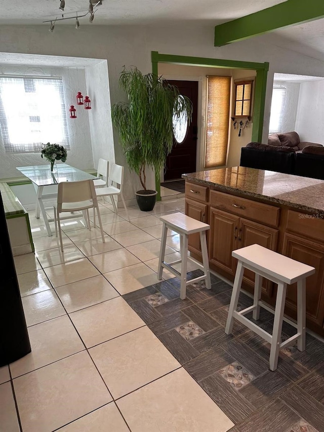 kitchen featuring a textured ceiling, tile patterned flooring, and lofted ceiling