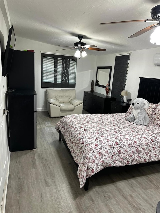 bedroom featuring hardwood / wood-style flooring, ceiling fan, and a textured ceiling