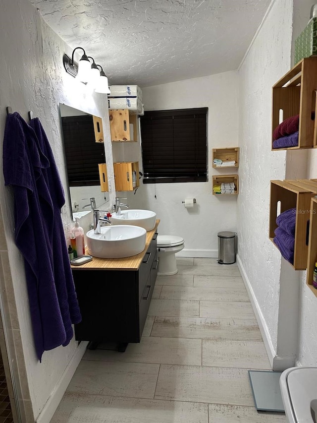 bathroom with vanity, wood-type flooring, a textured ceiling, and toilet