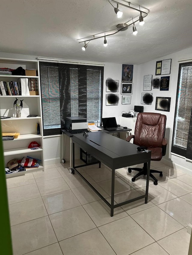 tiled home office featuring a textured ceiling and track lighting