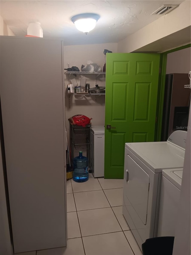 laundry room with light tile patterned floors and washing machine and clothes dryer