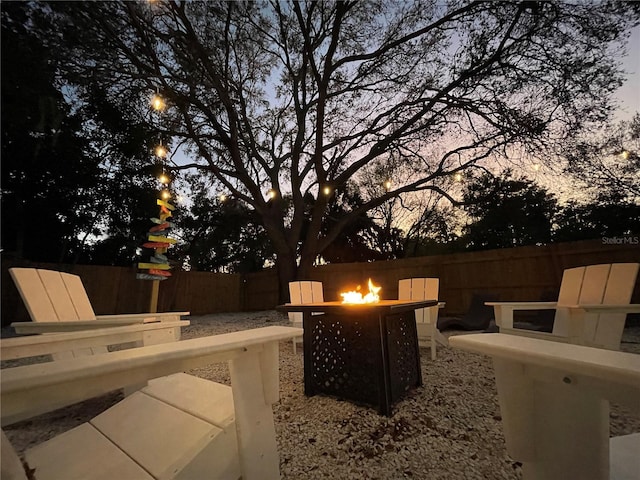 patio terrace at dusk featuring an outdoor fire pit