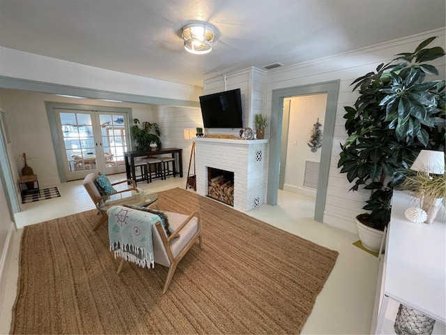 living room with french doors and a brick fireplace