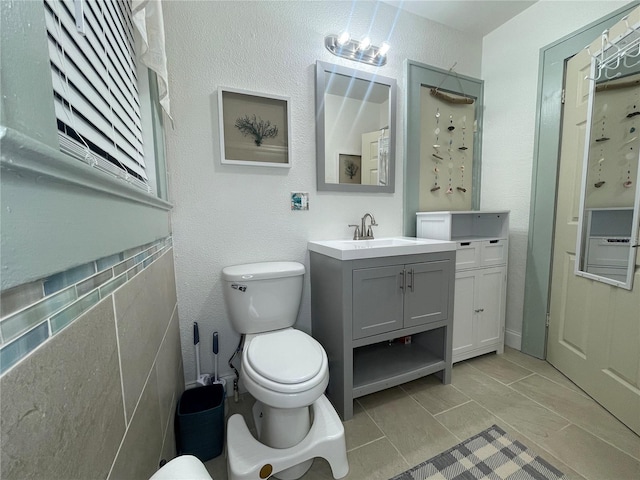 bathroom featuring tile patterned floors, vanity, and toilet