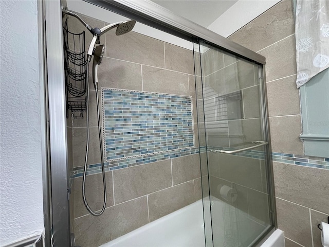 bathroom with combined bath / shower with glass door