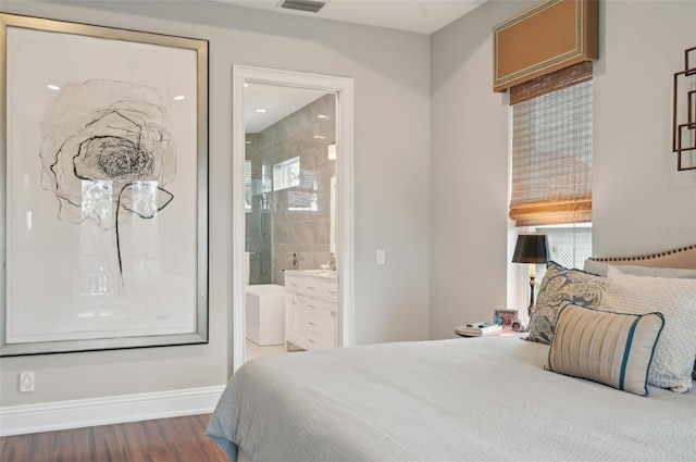 bedroom featuring connected bathroom and dark hardwood / wood-style flooring