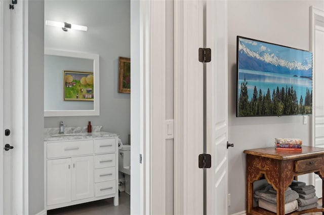 bathroom with toilet, vanity, and tile patterned floors