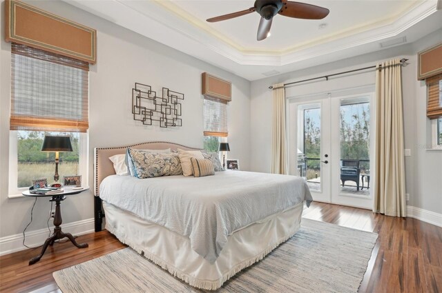 bedroom featuring french doors, access to exterior, dark hardwood / wood-style floors, ceiling fan, and a tray ceiling