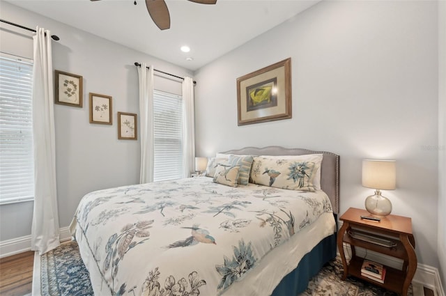 bedroom featuring ceiling fan, multiple windows, and wood-type flooring