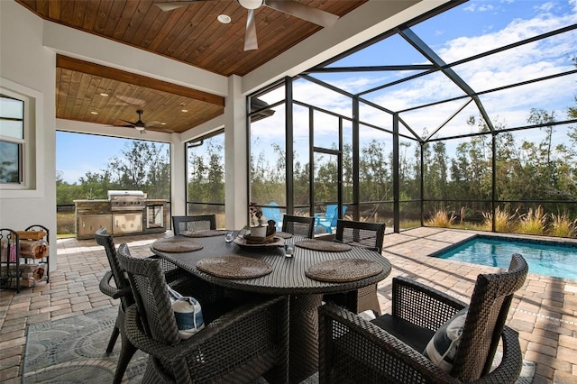 exterior space featuring a lanai, an outdoor kitchen, ceiling fan, and a grill