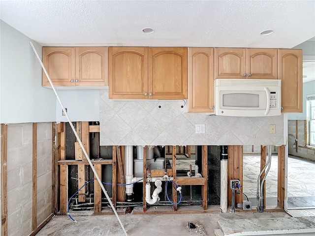 kitchen featuring light brown cabinetry and a textured ceiling