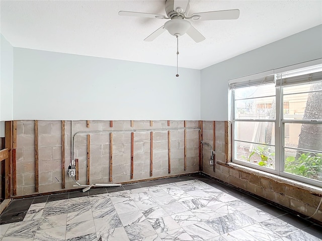 empty room featuring ceiling fan and a textured ceiling