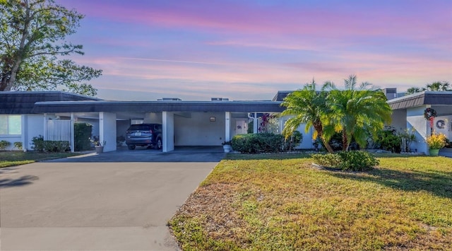 ranch-style home with a carport and a yard