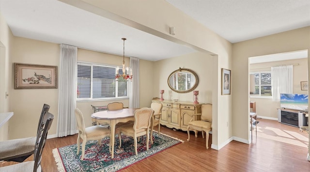 dining space with hardwood / wood-style flooring and a notable chandelier