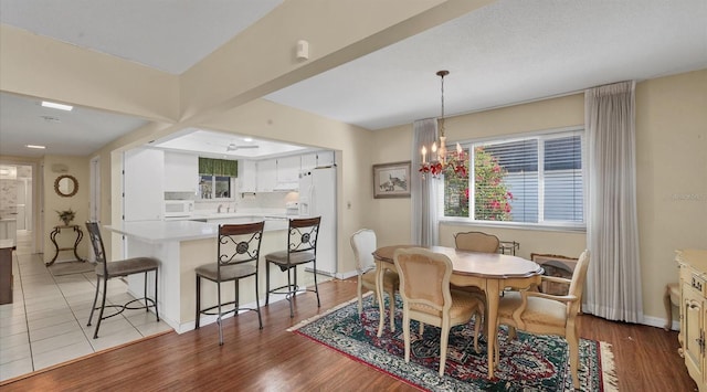 dining area with a notable chandelier and light wood-type flooring