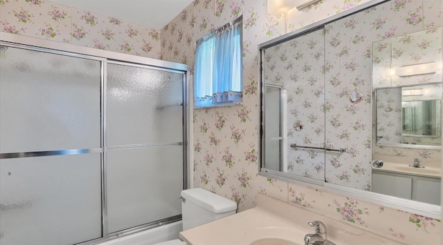 full bathroom featuring toilet, combined bath / shower with glass door, and vanity